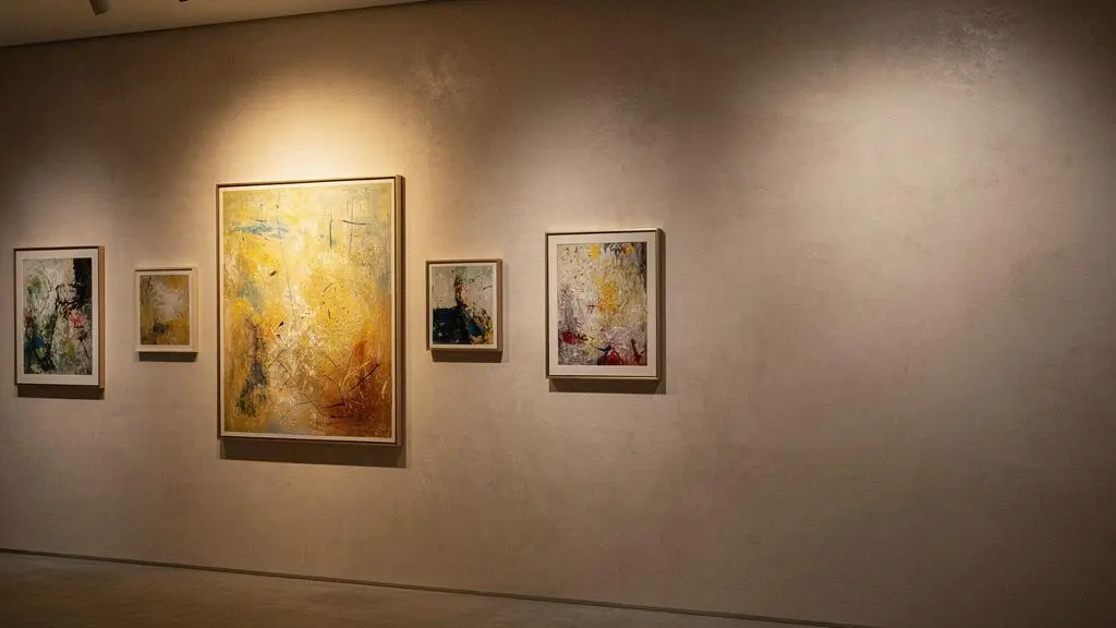 Mur de galerie présentant une collection d'œuvres d'art agencées avec cohérence, symbolisant une histoire visuelle continue