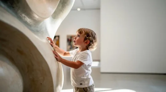 Un enfant vit une expérience de découverte artistique ludique et immersive au sein d'un musée lumineux