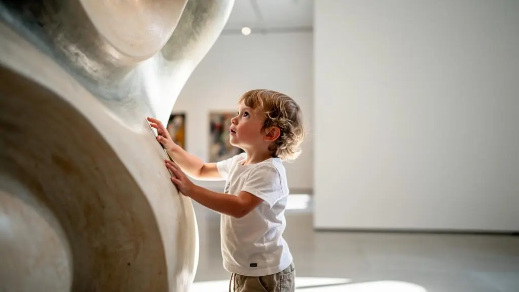 Un enfant vit une expérience de découverte artistique ludique et immersive au sein d'un musée lumineux