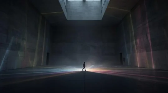 Une salle d'exposition vide transformée par des jeux de lumière numérique interactifs projetés au sol et sur les murs