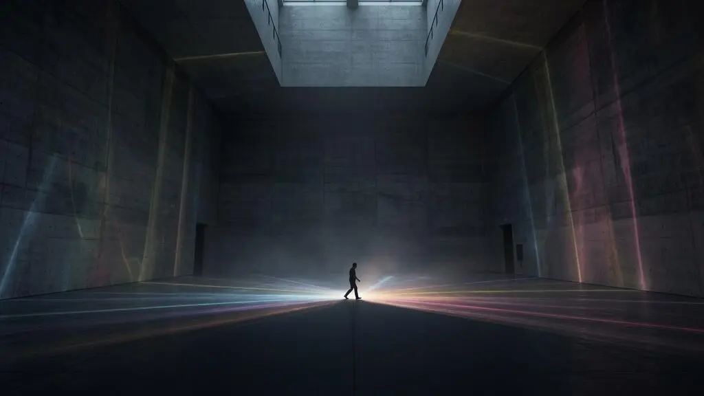 Une salle d'exposition vide transformée par des jeux de lumière numérique interactifs projetés au sol et sur les murs